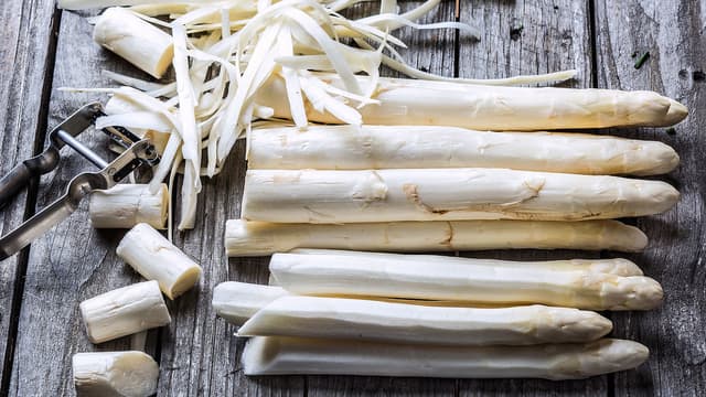 Skrell aspargesen fra der «blomsten» slutter og ned. La aspargesen ligge på fjøla mens du skreller for å unngå at den knekker. Skjær vekk de nederste 2–3 cm.