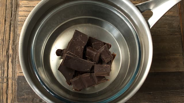 Smelt sjokolade sammen med smør i vannbad. Avkjøl sjokoladen litt før den helles over kaken, og strø over kokosmasse. Sett kaken kjølig litt til slik at sjokoladen stivner.