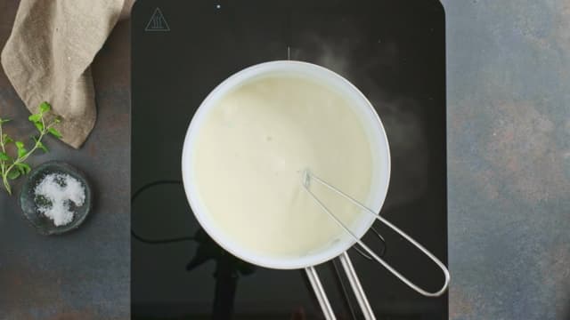 Start med å lage hvit saus ved å smelte smøret i en kjele. Pisk inn melet og la frese i 2 minutter.