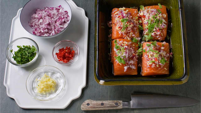 Finhakk løk, chili, ingefær og koriander. Fordel halvparten over laksen og stek i ovnen på 180 °C, i ca. 12-16 min.