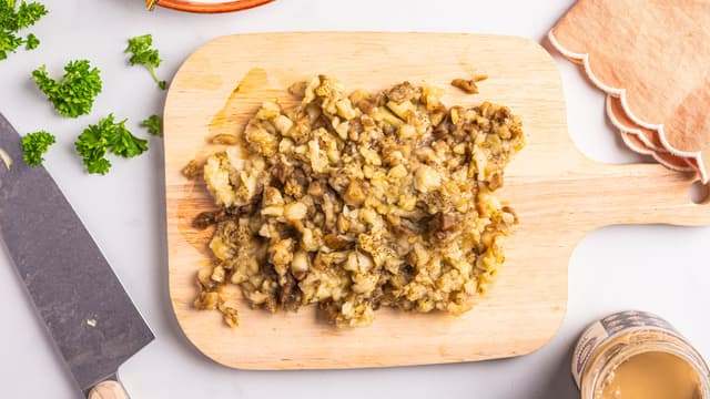 Finhakk auberginekjøttet og ha det i en bolle. Venn inn tahini, hvitløk og persille. Smak til med salt og pepper.