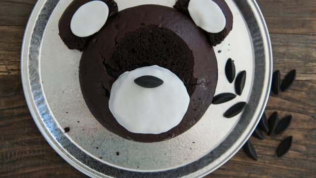 Kjevle ut hvit fondant eller marsipan slik at du har nok til å kle snuten til bamsen. Legg hvit fondant/marsipan forsiktig over sjokoladekake-nesen. Lag former til hvitt inni ørene til bamsen.