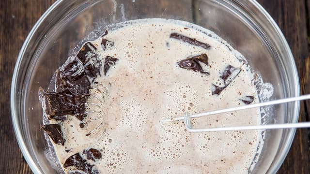 Hell den varme melkeblandingen over sjokoladen og visp til sjokoladen er helt smeltet. Avkjøl til romtemperatur.