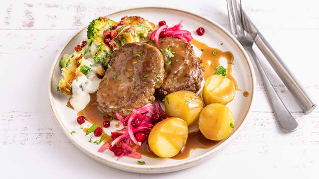 Stekte karbonader i brun saus med kokte poteter og grønnsaker