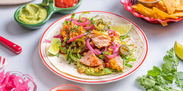 Fyll tacolefsene med guacamole, salat, laks, syltet rødløk og jalapenos. Topp med rømme og salsa før servering.