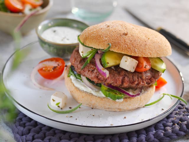 **Server burgerne** med varme, gode burgerbrød, gresk salat, tzatziki og ovnsbakte båtpoteter.