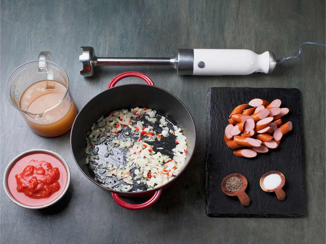 Fres løk, hvitløk og chili i olivenolje i en kjele. Tilsett tomater og kraft, kjør suppen jevn med en stavmikser, tilsett pølsebiter og kok opp.