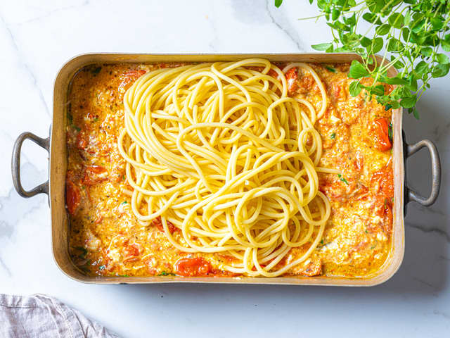 Hell vannet av pastaen og ha den oppi formen med tomater og fetaost.