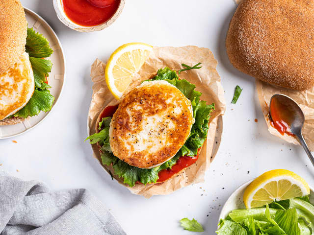 Server fiskeburgeren i burgerbrød med ketsjup.