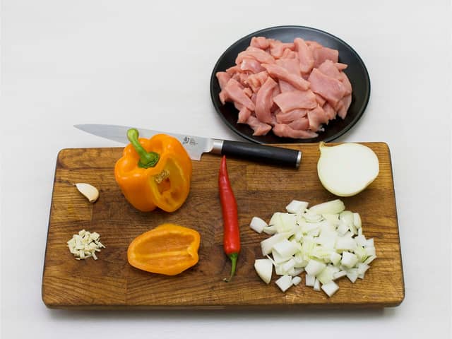 Skjær svinefileten i strimler og paprika i biter. Hakk løk, hvitløk og chili.