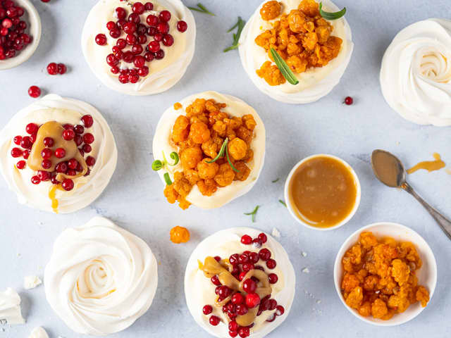 **Marengs med tyttebær:** Legg marengsbunnene på pene desserttallerkener og topp lagvis med karamell, krem og frosne tyttebær. Knus krumkaker og strø på toppen.