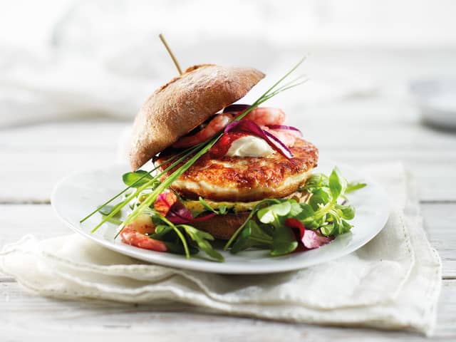 Grov fiskeburger toppet med reker og rødløk