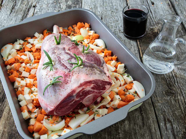 **Rotgrønnsaker:** Del grønnsakene i jevne biter/staver og ha dem i en langpanne. Hell over 1 liter vann, og legg lammelåret på toppen.