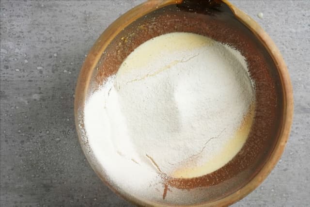 Rør smørblandingen sammen med de tørre ingrediensene i en bolle til du har en jevn kakerøre. Hell røren i en smurt langpanne.