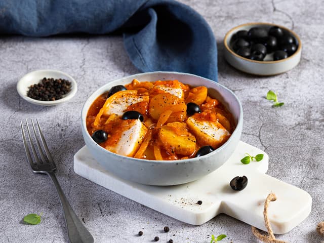 Skru ned varmen og legg fiskeskivene på toppen av tomatsausen. Sett på lokk og la trekke i 5 minutter. Smak til med salt og pepper.