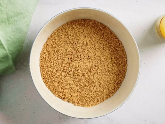 Kle bunnen av en springform på ca. 24-26 cm med bakepapir. Ha kjeksblandingen i formen og klem den utover med baksiden av en skje eller en slikkepott. Sett formen i kjøleskapet mens du lager fyllet.