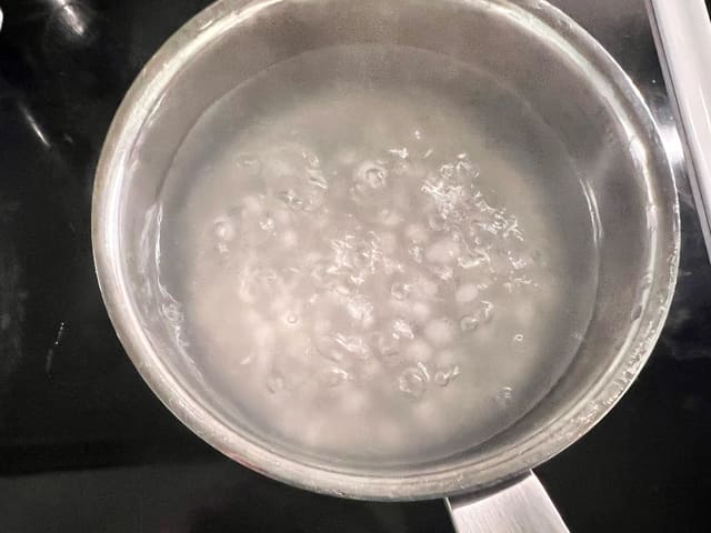 **Tapiokaperler:** Kok opp vann i en kjele. Per 1 dl tørre tapiokaperler, bruker du minst 5 dl vann. Når vannet koker, har du i de tørre tapiokaperlene.