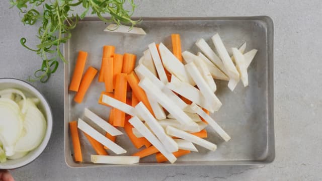 Ha gulrøtter, pastinakk og epler i en ildfast form. Vend inn honning, olivenolje, salt og pepper. **Stek grønnsakene i ovnen på 180 grader i ca 30 minutter** til de er gylne og møre.