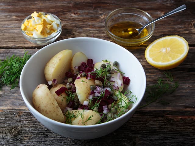 **Potetsalat:** Del de ferdigkokte potetene i to og bland dem sammen med finhakket rødløk, rødbete, kapers og dill. Bland sammen olivenolje og sitronsaft, smak til med salt og pepper. Hell dressingen over potetsalaten og bland forsiktig sammen. Topp det hele med finhakket, hardkokt egg.