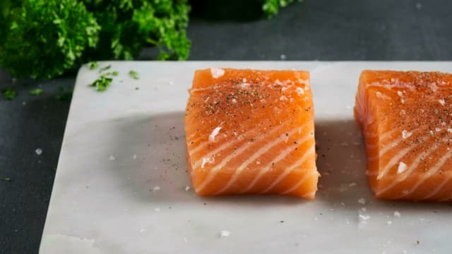 Krydre fisken med salt og pepper.