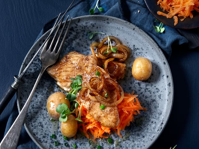 Fordel løken over fisken. Mens dette koser seg i pannen, river du gulrøttene og skviser over sitronsaft. Server sei med løk, nykokte poteter, finkuttet gressløk og smeltet smør.