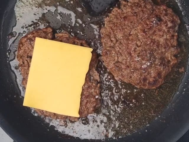 Ha cheddar på toppen av to av burgerne, og la dem frese videre i ca. 2 minutter til.