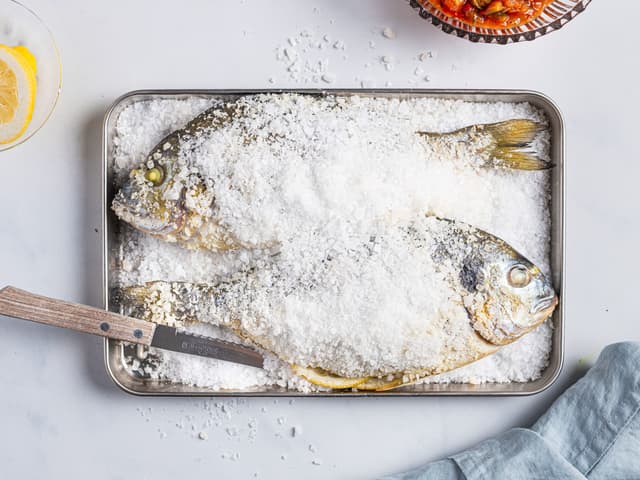 Ha litt av saltet i bunnen på en ildfast form. Legg i doradene og topp med resten av saltet. Stek fisken i ovnen på **200 grader i ca. 30 minutter.**