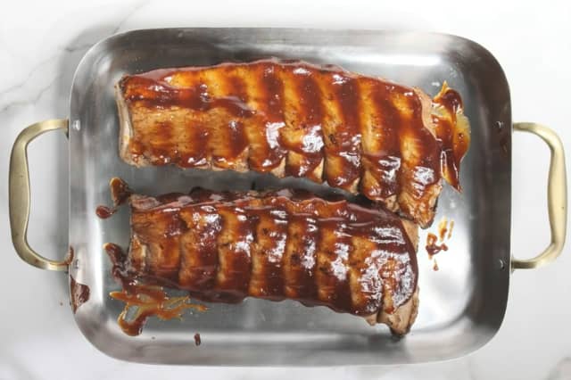 Legg de ferdigkokte spareribsene på et bakebrett og pensle med BBQ saus. Du kan enten steke dem ferdig på 180 grader i 20-30 minutter, midt i ovnen, eller du kan legge dem på indirekte varme på grillen i 20-30 minutter til de er gylne, møre og saftige.