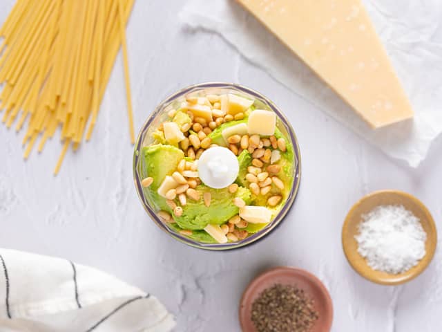 Ha avokado, hvitløk, parmesan, pinjekjerner, olivenolje og sitronsaft i en food prosessor eller blender. Kjør til en jevn grønn saus, det tar ca 1 minutt. Spe med litt ekstra olivenolje eller vann hvis kremen blir for tykk. Smak til med salt, pepper og evt litt ekstra sitronsaft.