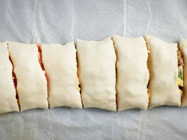 Skjær pølsen i 1,5 cm tykke skiver og legg på et bakebrett dekket med bakepapir.