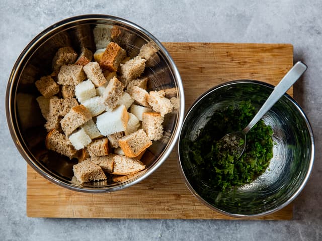 Bland sammen olje, salt, hvitløk og urter i en bolle. Vend brødet i blandingen.