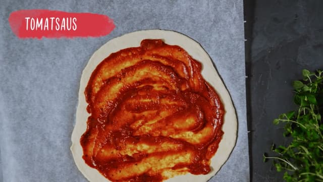 Smør tomatsausen utover pizzabunnen.