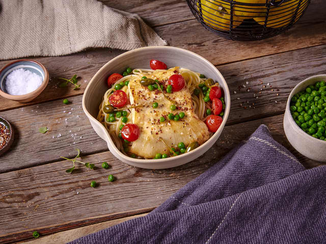 Stek erter, kapers og cherrytomater sammen med piggvaren de siste 2 minuttene. Ha i soyasausen mot slutten av steketiden. Ha pastaen i serveringsboller og topp den med fisk, grønnsaker og saus like før servering.