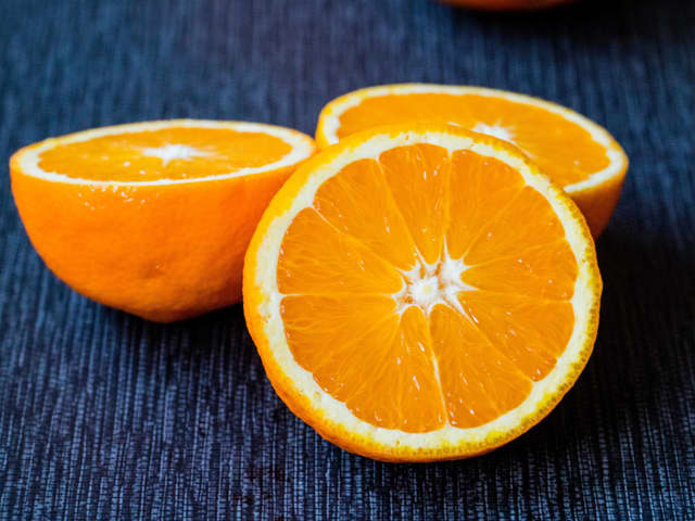 Skrell og riv gulrøttene. Skjær av skallet på appelsinene og skjær ut appelsinfileter. Bland sammen gulrøtter og appelsin.