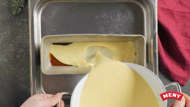 Dra kjelen til siden, klem ut vannet av gelatinplatene og rør en og en geletinplate inn i melken.