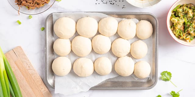 **Steamed buns:** Når deigen er ferdig hevet, deler du den i 14-16 like emner. Rull emnene til små boller.