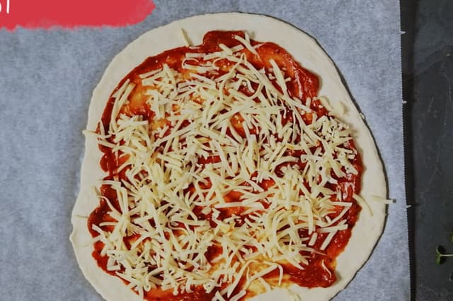 Legg pizzabunnene utover benken. Fordel pizzasaus og ost utover pizzabunnene.
