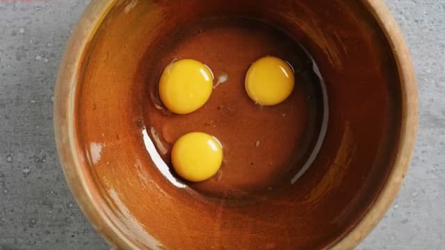 Rør sammen eggeplommene og sukker i en kjele. Tilsett fløteblandingen i tynn stråle mens du pisker. Sil blandingen.
