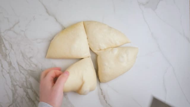 Del deigen i 4, da passer hver deig til en stor, tynn pizzabunn. Elt deigen mellom hendene, lag 4 fine små boller og legg dem på et oljet fat med god avstand mellom hver.