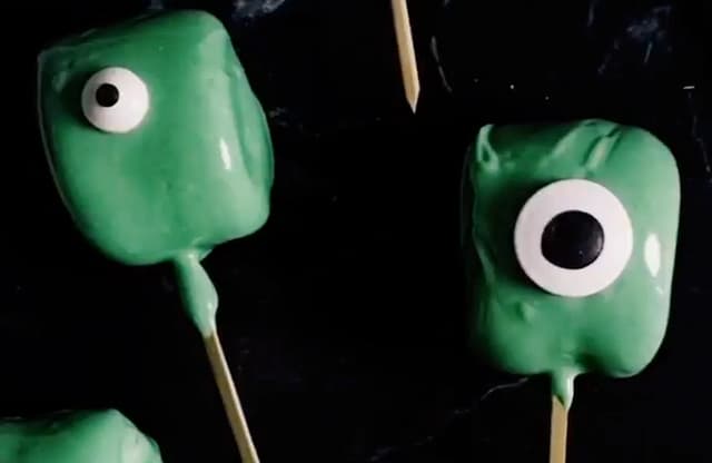 Stikk en marshmallows på grillpinne og dypp den i sjokoladen til hele er dekket. Sett på et spiselig øye og sett sjokoladen i kjøleskapet så den stivner. Om du ikke får kjøpt spiselige øyne, kan du lage det med melisglasur og lakris.