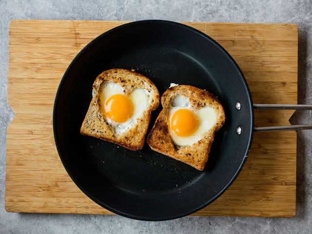 Legg den ustekte siden av brødet tilbake i pannen og tilsett egg. Stek egg og brød sammen.