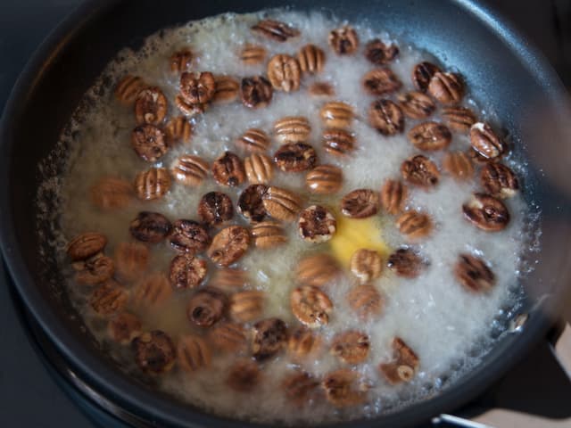 Ha honning og smør i stekepannen og la det smelte sammen. Ha i nøttene og la dem putre i 1-2 minutter.