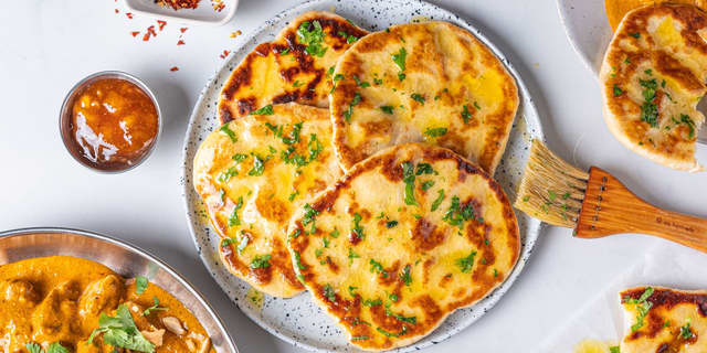 Mens risen varmes, har du naan brødene midt i ovnen på **180 grader i ca. 5 minutter** til de er varme.