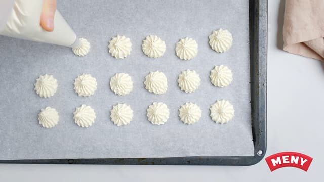 Ha blandingen i en sprøytepose og sprøyt 30 mandeltopper på et bakebrett dekket med bakepapir.
