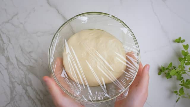 Flytt deigen over i en bolle penslet med et tynt lag olivenolje, og pensle også toppen av deigen så den ikke tørker ut. Dekk til med plastfolie og la den stå i kjøleskap i 18 timer.