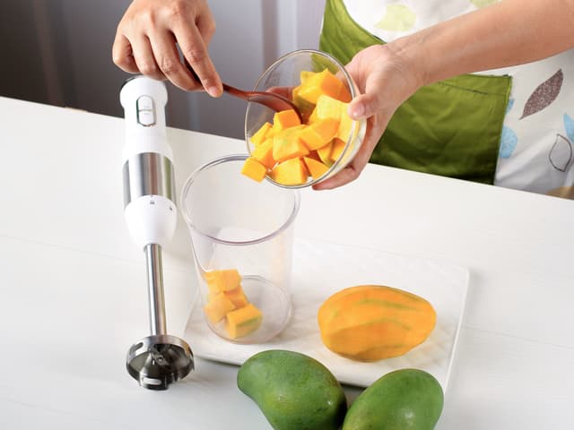 Ha mangoterninger, yoghurt, melk, kardemomme og sukker i en blender og kjør til den blir helt jevn