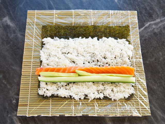 Legg strimler av laks i en stripe på risen sammen med mango, avokado eller agurk. Du kan ha alt i en makirull, eller lage flere forskjellige typer.