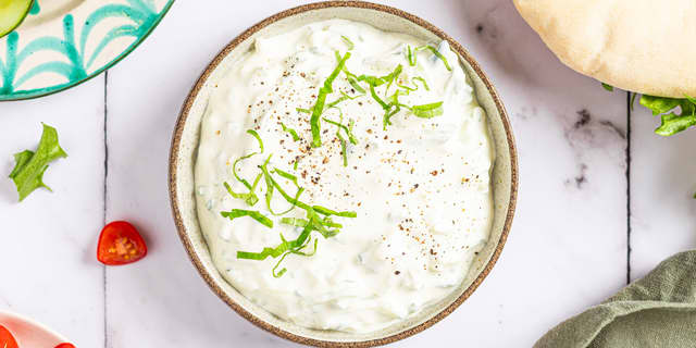 Finhakk hvitløksfeddene og bland med agurk og yoghurt. Smak til med skall og saft fra sitronen, salt og pepper.