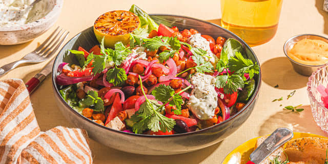 Anrett gresk salat i en bolle, og topp med sprø kikerter og syltet rødløk. Du kan også lage en enkel hjemmelaget gresk salat, av gode tomater, agurk, rødløk og fetaost i terninger.
