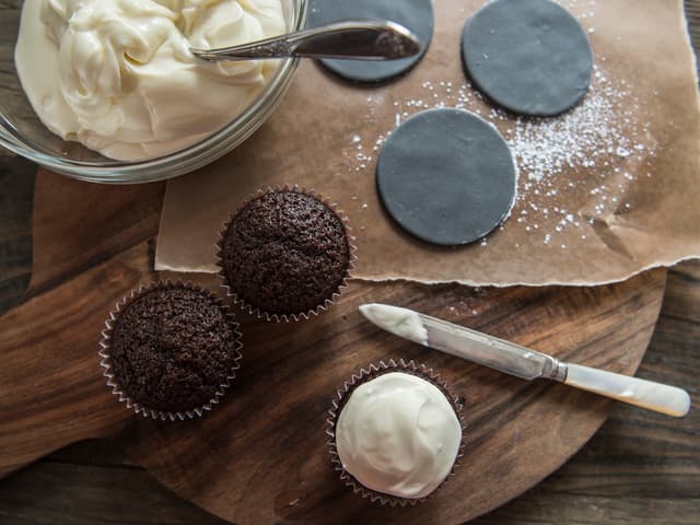 Pynte elefant: Legg et tynt lag med kremostfrosting på cupcaken. Kjevle ut grå fondant, bruke
melis til å arbeide med fondanten. Bruk et glass eller rund form som er litt større enn cupcaken
til å hulle ut et rundt lag som man legger oppå cucaken.
